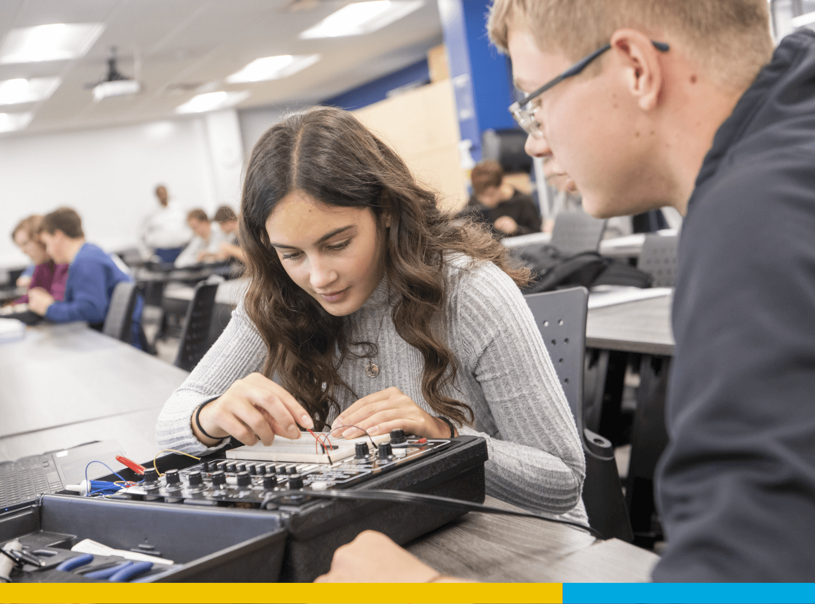 Two students wiring equipment